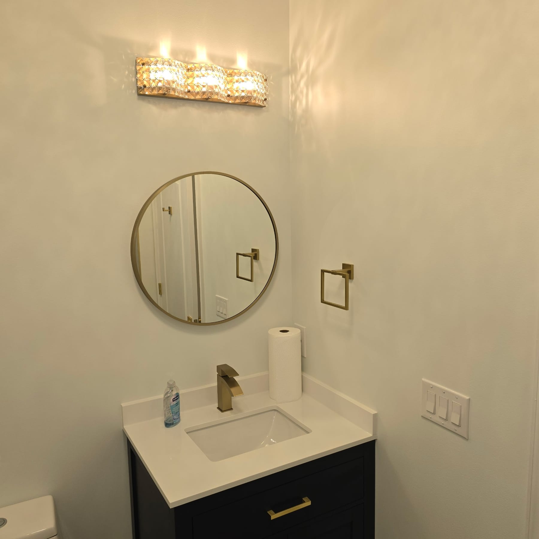 Navy vanity with round gold mirror